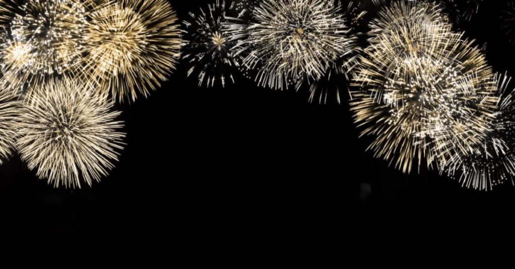 Golden fireworks dot a dark night sky.